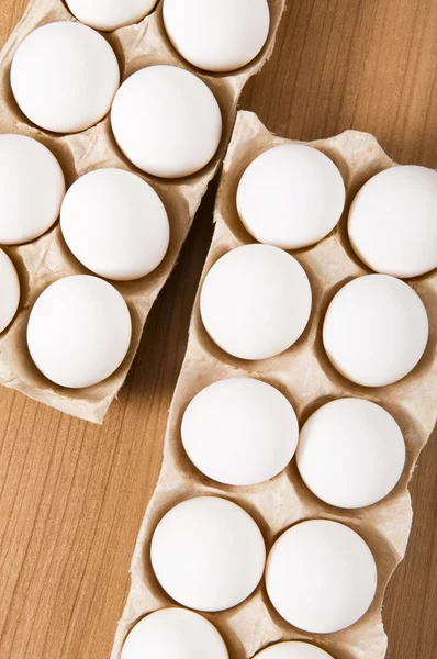 Mnoho bílých vajec na dřevěný stůl — Stock fotografie