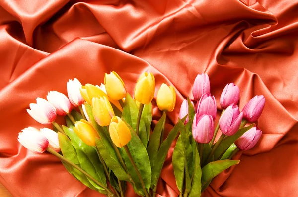 Sok virág a vörös szatén háttér — Stock Fotó