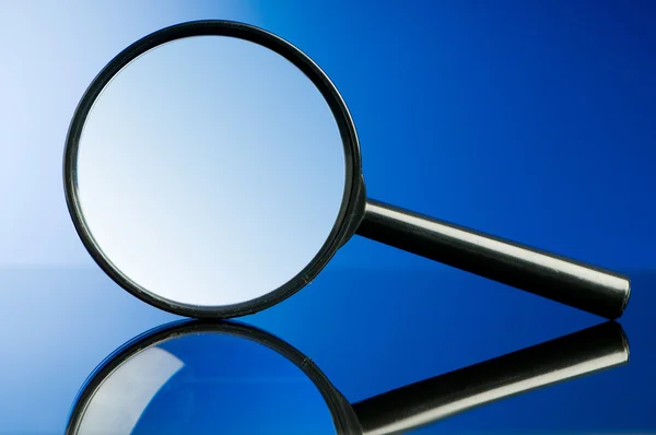 Magnifying glass with wooden handle on the flat surface — Stock Photo, Image