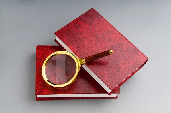 stock image Magnifying glass over the stack of books