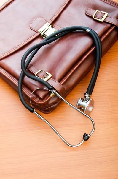 Doktorsväska med stetoskop mot trä bakgrund — Stockfoto