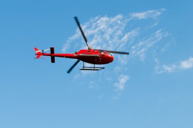 Red helicopter on the bright summer day clipart