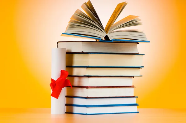 Diploma y pila de libros sobre el fondo — Foto de Stock