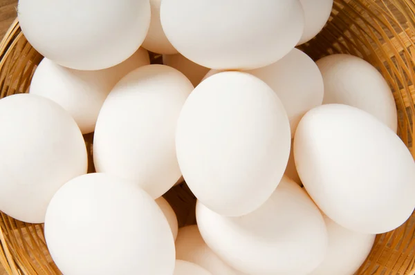 De nombreux œufs blancs sur la table en bois — Photo