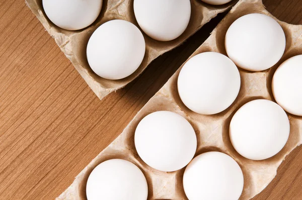 De nombreux œufs blancs sur la table en bois — Photo