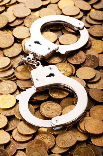 Hand cuffs and coins as security concept