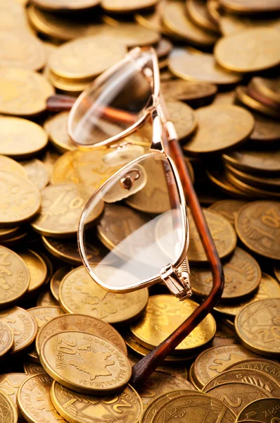 Många mynt och läsglasögon som affärsidé — Stockfoto