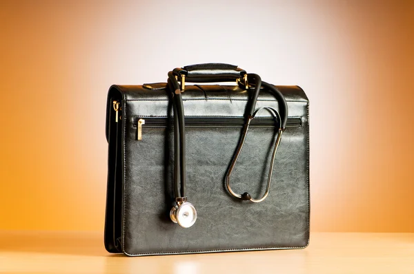 Arztkoffer mit Stethoskop vor buntem Hintergrund — Stockfoto