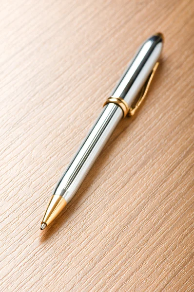 Написание серебряной ручки на деревянном фоне — стоковое фото
