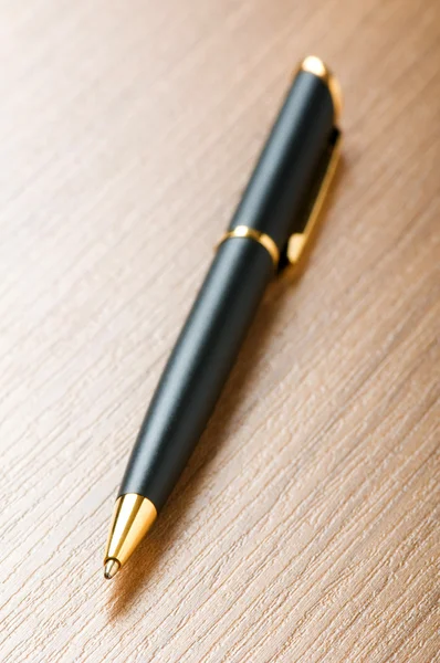 Zilveren pen schrijven op de houten achtergrond — Stockfoto