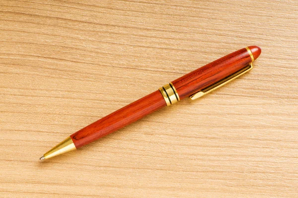 Zilveren pen schrijven op de houten achtergrond — Stockfoto