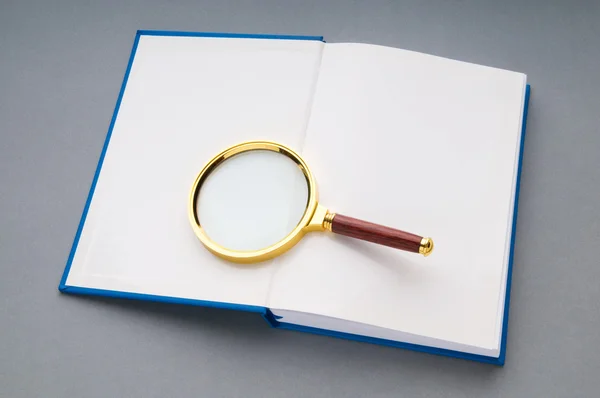 書籍のスタック上の拡大鏡 — ストック写真