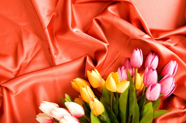 Mnoho Květin Červeném Saténovém Pozadí — Stock fotografie