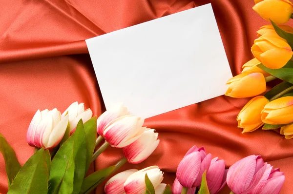 Envelope e flores no fundo de cetim — Fotografia de Stock