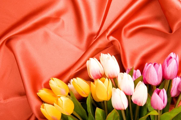Muchas flores en el fondo de satén rojo —  Fotos de Stock