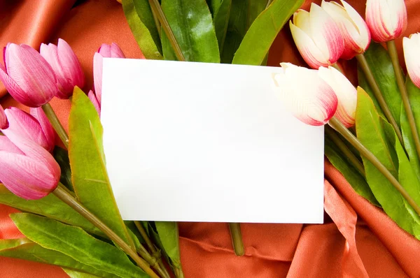 Envelope e flores no fundo de cetim — Fotografia de Stock