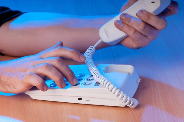 Hands dialing phone buttons in the darkness — Stock Photo, Image