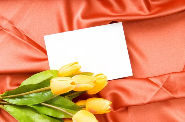 Umschlag und Blumen auf dem Satin-Hintergrund — Stockfoto