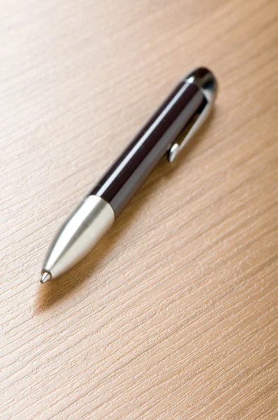 Zilveren pen schrijven op de houten achtergrond — Stok fotoğraf