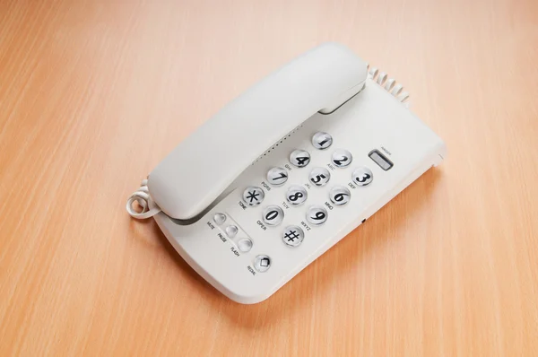 Белый офисный телефон на плоской поверхности — стоковое фото