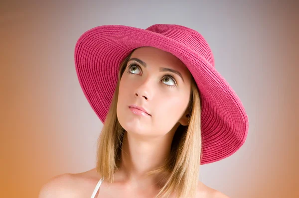 Giovane ragazza con cappello da spiaggia contro sfondo gradiente — Foto Stock