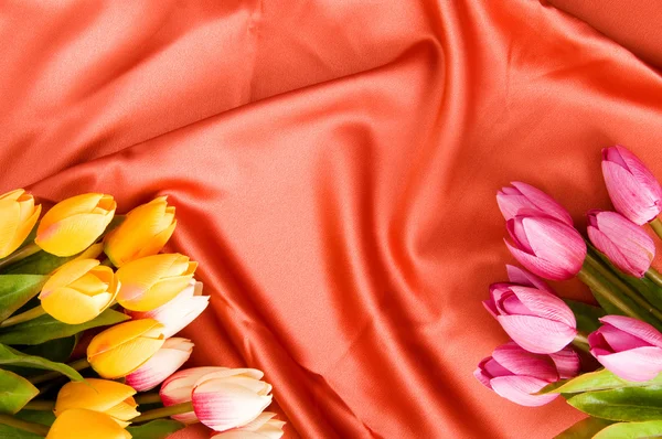 Много Цветов Красном Атласном Фоне — стоковое фото