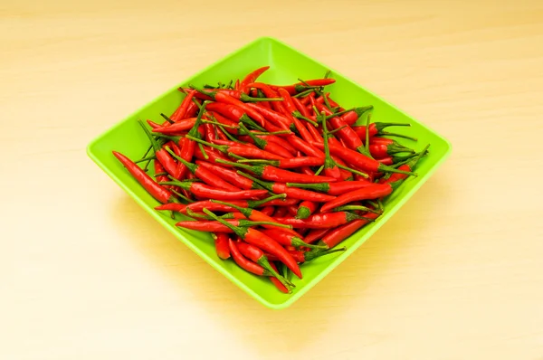 Varm paprika i plattan på träbord — Stockfoto