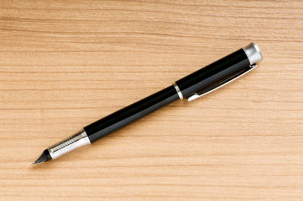 Запис срібної ручки на дерев'яному фоні — стокове фото