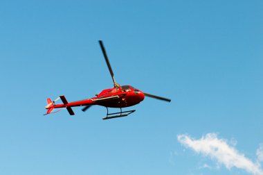 Red helicopter on the bright summer day clipart