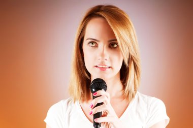 Girl singing with microphone against gradient background clipart