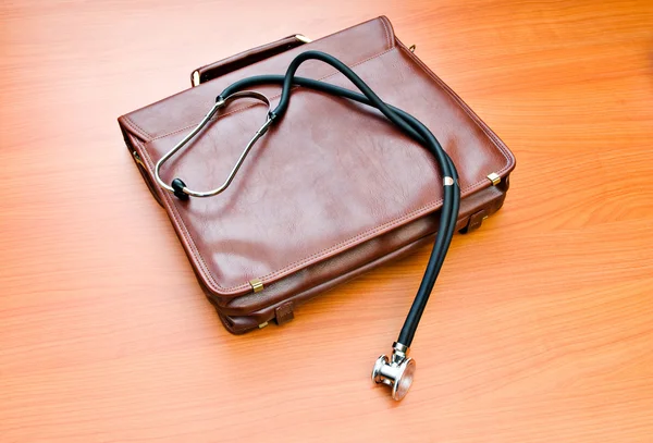 Doctor's case with stethoscope against wooden background — Stock Photo, Image