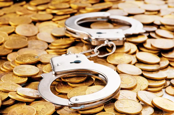 Hand cuffs and coins as security concept — Stock Photo, Image