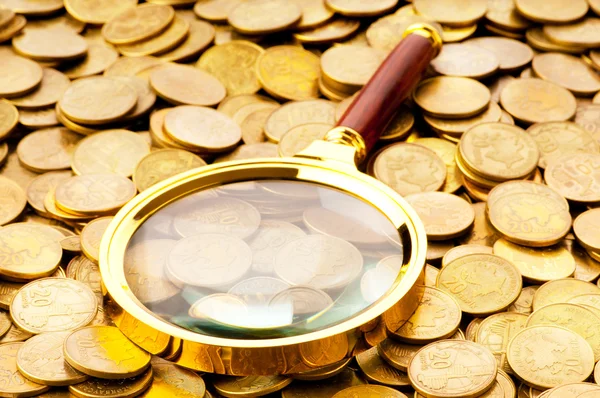 Nagyító és -érmék a háttérben — Stock Fotó
