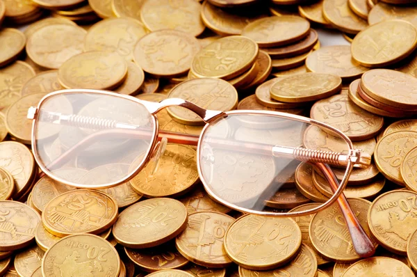 stock image Many coins and reading glasses as business concept