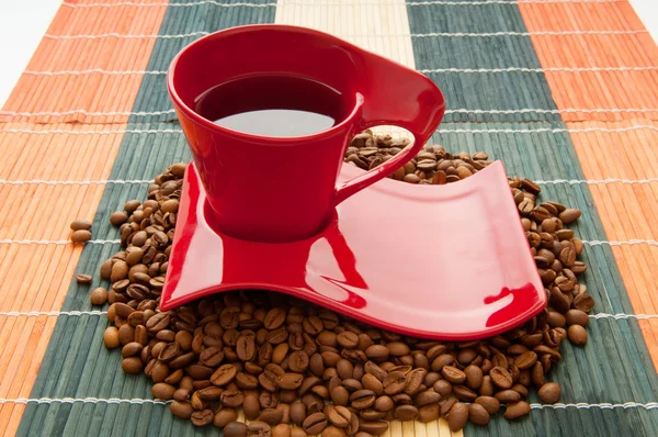 Cup of coffee with many beans around — Stock Photo, Image