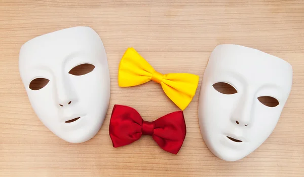 Masks and bow ties on the wooden background — Stock Photo, Image