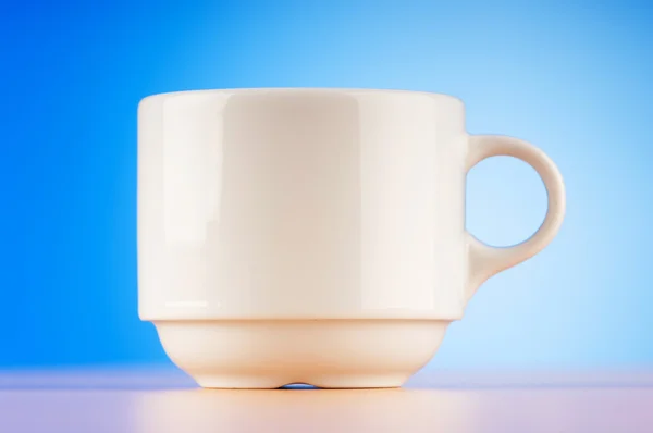 Λευκό Cup Εναντίον Πολύχρωμα Ντεγκραντέ Στον Πίνακα — Φωτογραφία Αρχείου