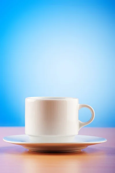 Copa blanca contra gradiente de colores en la mesa — Foto de Stock