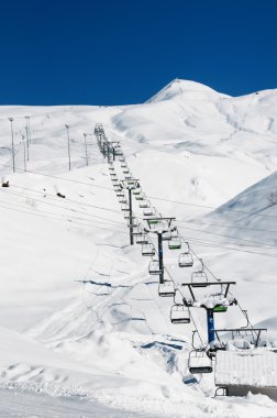 Aydınlık kış gününde kayak kaldırma koltukları