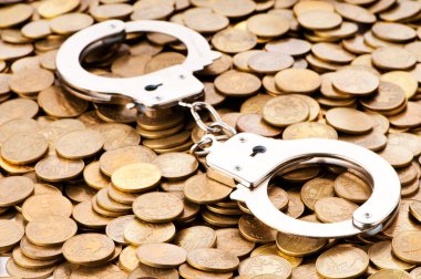 Hand cuffs and coins as security concept clipart