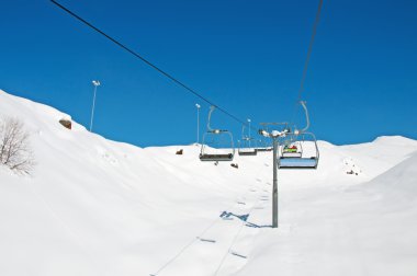 Aydınlık kış gününde kayak kaldırma koltukları