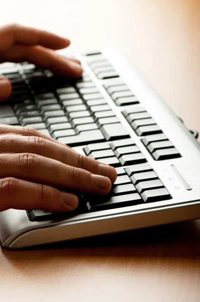 Dos manos trabajando en el teclado plateado —  Fotos de Stock