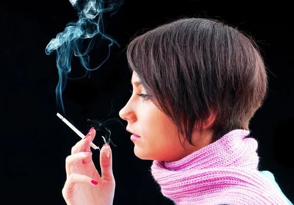 Молода дівчина палить на чорному — стокове фото