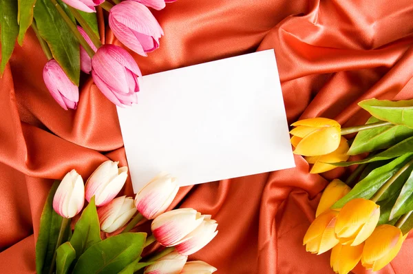 Φάκελος και λουλούδια στο σατέν φόντο — Φωτογραφία Αρχείου