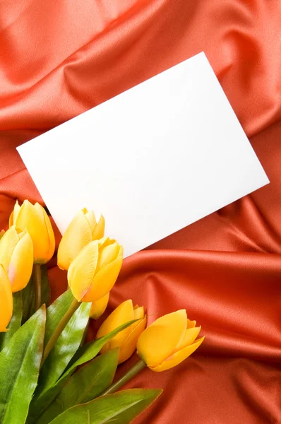 Envelop en bloemen op de satijnen ondergrond — Stockfoto