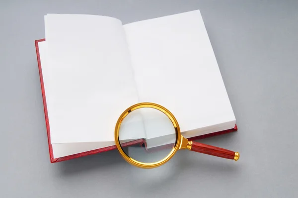 書籍のスタック上の拡大鏡 — ストック写真