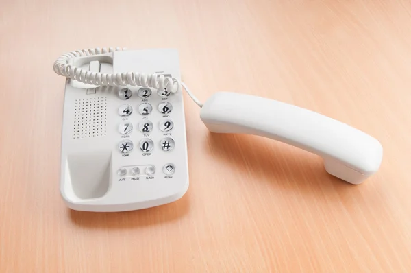 Weißes Bürotelefon auf der flachen Oberfläche — Stockfoto