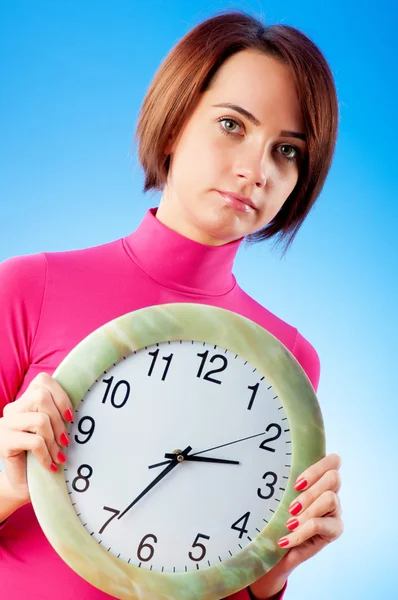 Młoda kobieta trzyma okrągły zegar w rękach — Zdjęcie stockowe