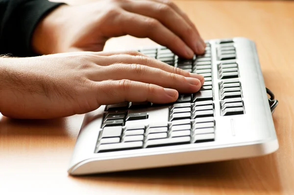 Two hands working on the silver keyboard — Stock Photo, Image