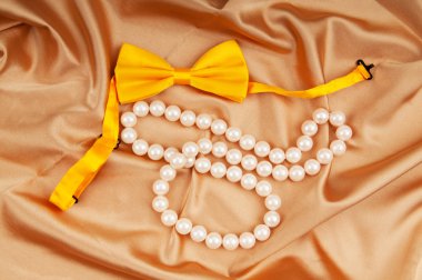 Bow ties and pearl necklace on the satin clipart